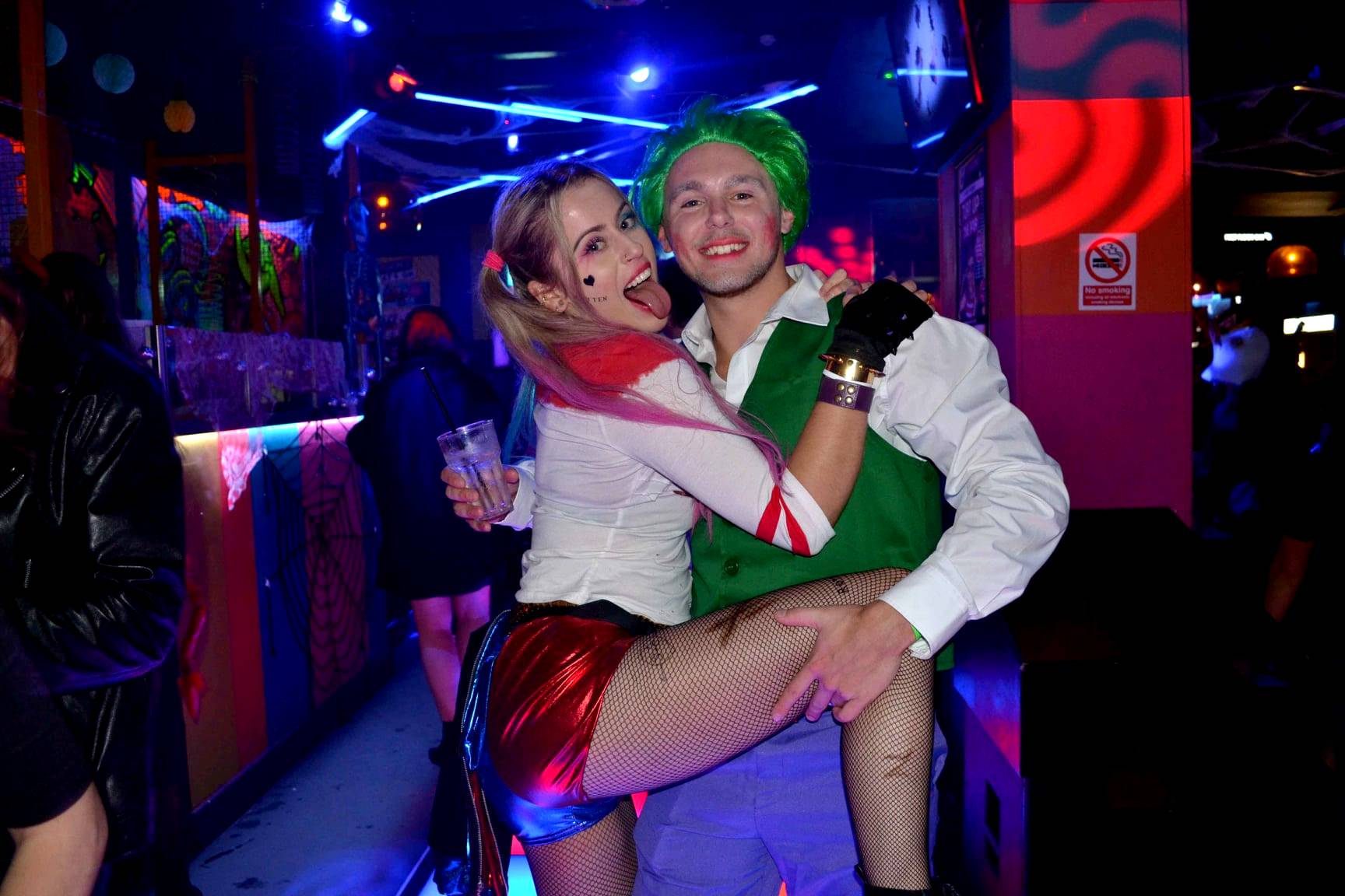 Two characters - harley quinn and the joker - pose for a photo on the Halloween pub crawl on Brighton's best night out